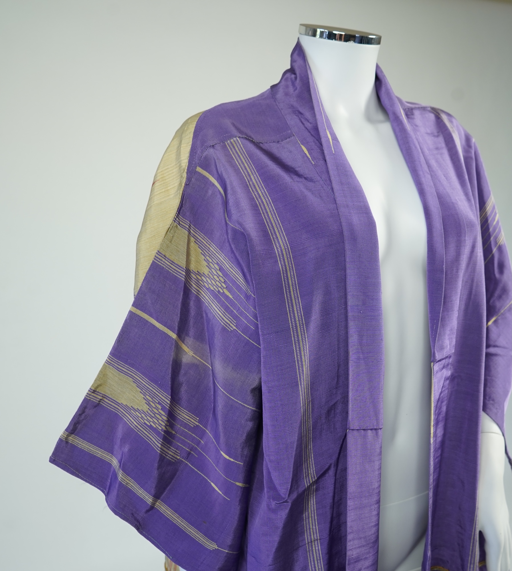An early 20th century Syrian hand woven silk coat. Woven with stripes and geometric shapes in purple and yellow and red., 130 cm long. Condition - good, colours and fabric strong.